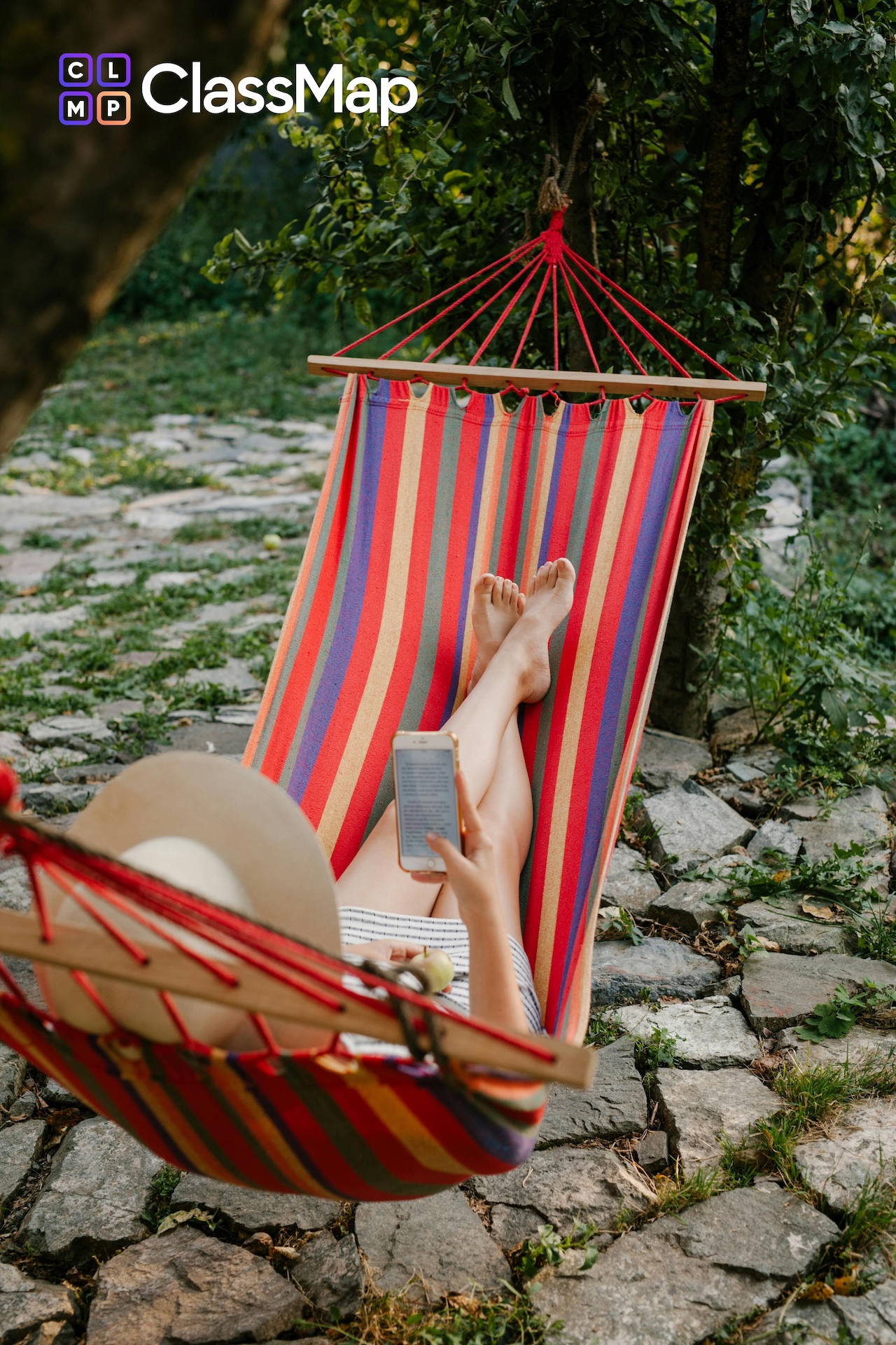 Person with a hat sitting in a hammock in a relaxing environment